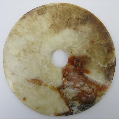 9 - A Chinese white and russet jade bi disc, Neolithic style, probably late 19th/20th century. Supported... 