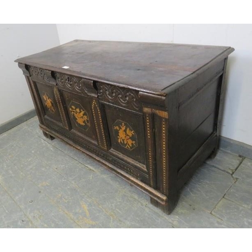 703 - A late 17th/early 18th century panelled oak coffer, the front with carved frieze and marquetry inlay... 