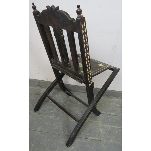 707 - A vintage Syrian hardwood folding chair with turned finials, having profuse mother of pearl inlay, o... 