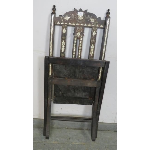 707 - A vintage Syrian hardwood folding chair with turned finials, having profuse mother of pearl inlay, o... 