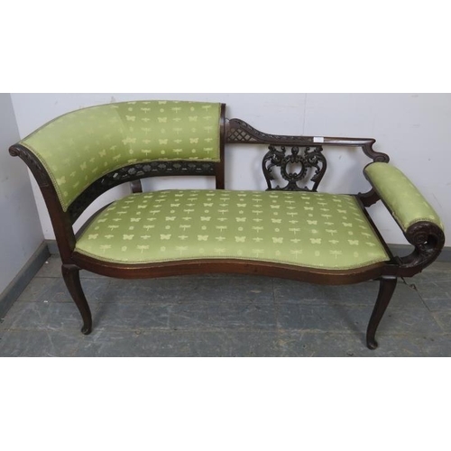 717 - An Edwardian mahogany chaise longue of small proportions, the ornately carved and pierced backrest w... 