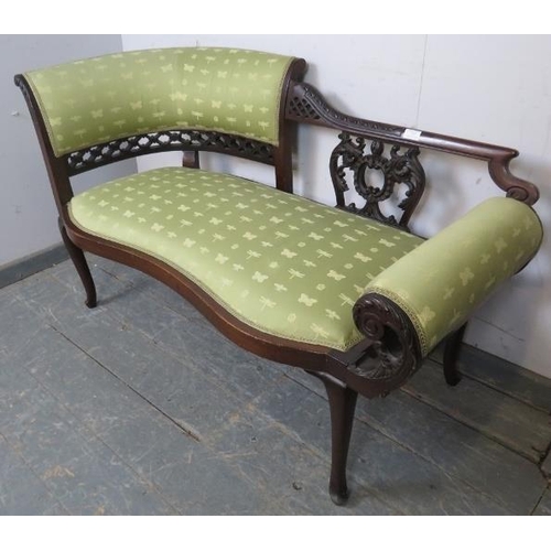 717 - An Edwardian mahogany chaise longue of small proportions, the ornately carved and pierced backrest w... 