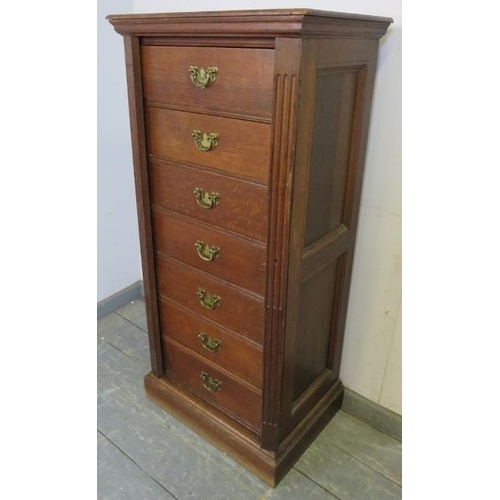 719 - A 19th century oak Wellington chest, having seven long drawers with fancy brass handles, flanked by ... 