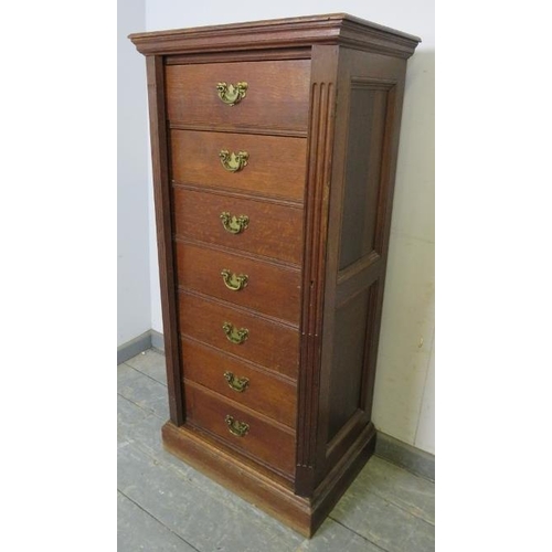 719 - A 19th century oak Wellington chest, having seven long drawers with fancy brass handles, flanked by ... 