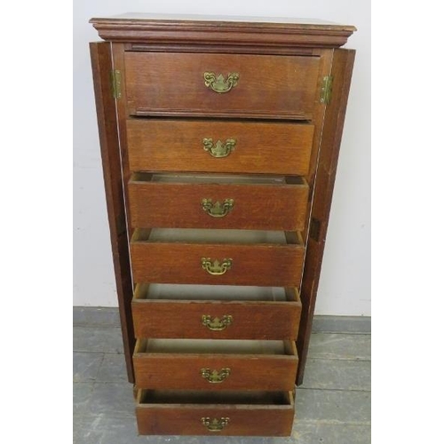 719 - A 19th century oak Wellington chest, having seven long drawers with fancy brass handles, flanked by ... 