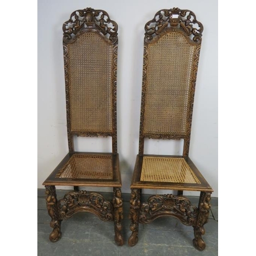 724 - A pair of 19th century fruitwood high back bergère hall chairs in the Carolean taste, the carved and... 