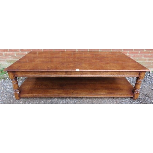 727 - A large antique style solid oak coffee table, on turned and block supports united by an undertier sh... 