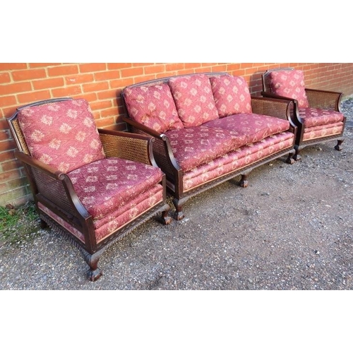 728 - An antique mahogany bergère three-piece suite, comprising a two-seater sofa and two armchairs, uphol... 