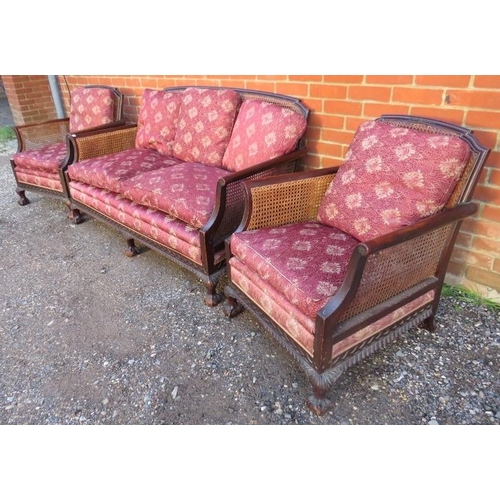 728 - An antique mahogany bergère three-piece suite, comprising a two-seater sofa and two armchairs, uphol... 