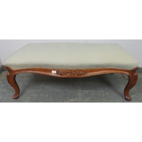 732 - A large 19th century walnut serpentine edged footstool, reupholstered in neutral material, the friez... 