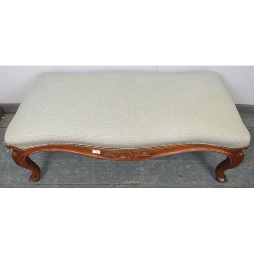 732 - A large 19th century walnut serpentine edged footstool, reupholstered in neutral material, the friez... 