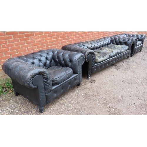 734 - A vintage three-piece Chesterfield suite, comprising a three-seater sofa and two club armchairs, uph... 