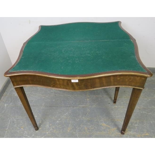 745 - A Georgian mahogany serpentine fronted folding card table, on chamfered tapering square supports. 
H... 