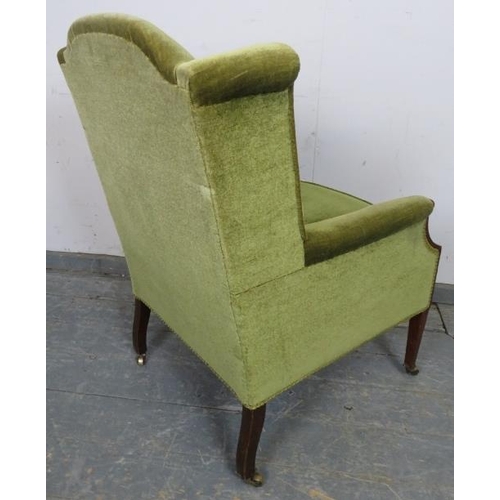 751 - An Edwardian mahogany wingback armchair, upholstered in green velvet material, strung with satinwood... 