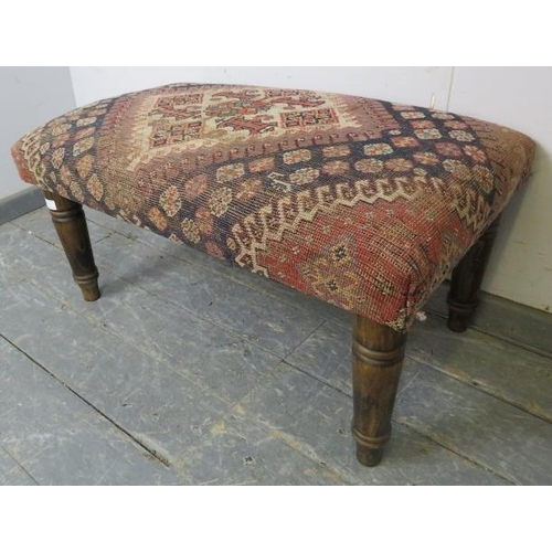 757 - A contemporary footstool recovered with an antique Egyptian carpet, on turned tapering fruitwood sup... 