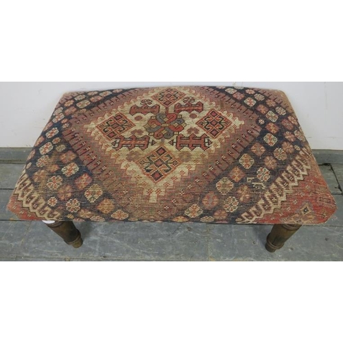 757 - A contemporary footstool recovered with an antique Egyptian carpet, on turned tapering fruitwood sup... 