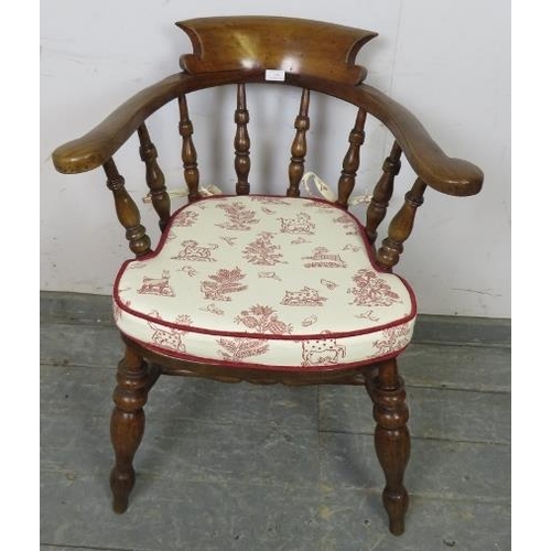 759 - A turn of the century elm and beech captain’s chair with turned spindles, on canted turned supports ... 