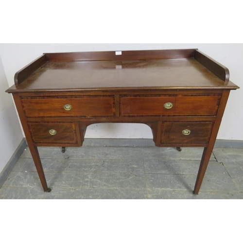 763 - An Edwardian mahogany kneehole writing desk, having ¾ gallery above two long and two short crossband... 