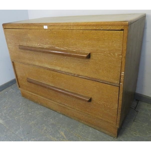 765 - An Art Deco limed oak chest housing two long and deep drawers with scalloped handles, on a plinth ba... 