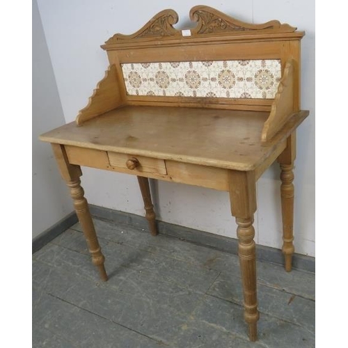 768 - An antique pine washstand, having acanthus carved and scrolled cornice, above an inset tile back, on... 