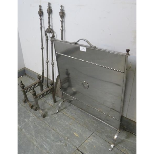 788 - An Edwardian polished steel fireguard, together with good quality steel companion set and fire dogs.... 