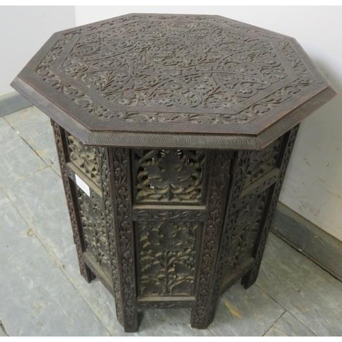 793 - An antique Anglo Indian hardwood octagonal table, the top with relief carved foliate motifs, on a ca... 