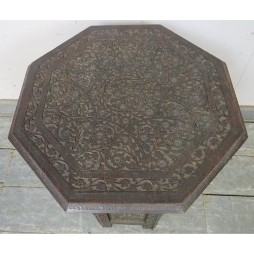 793 - An antique Anglo Indian hardwood octagonal table, the top with relief carved foliate motifs, on a ca... 