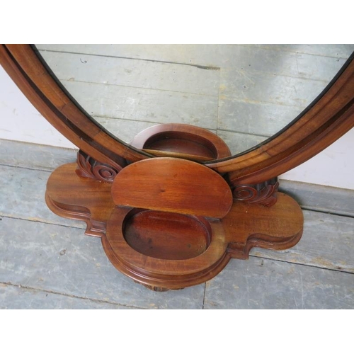 807 - A Victorian mahogany oval swing vanity mirror with scrolled uprights, on a shaped plinth base with c... 