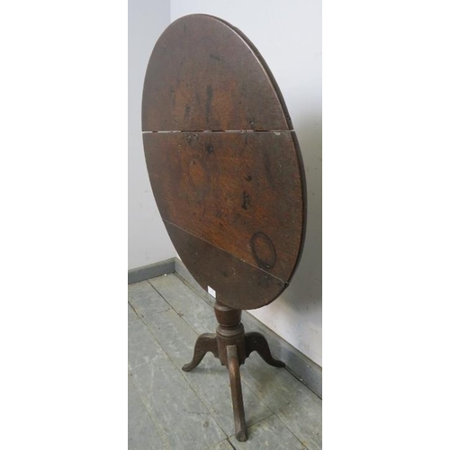 824 - A Georgian oak tilt-top wine table, on a tapered column with tripod supports.
H64cm Diameter 68cm (a... 