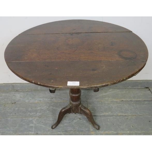 824 - A Georgian oak tilt-top wine table, on a tapered column with tripod supports.
H64cm Diameter 68cm (a... 