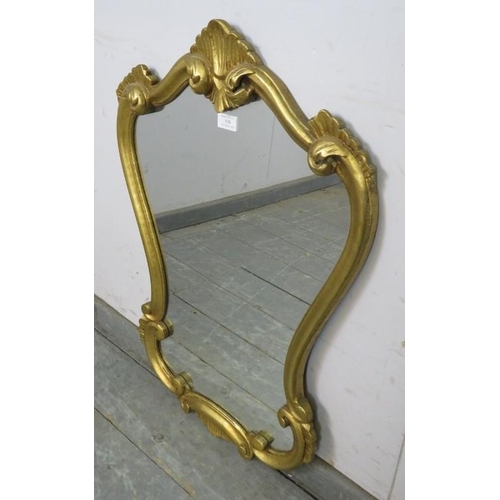 838 - A vintage giltwood wall mirror in the early Georgian taste, within a shaped surround decorated with ... 