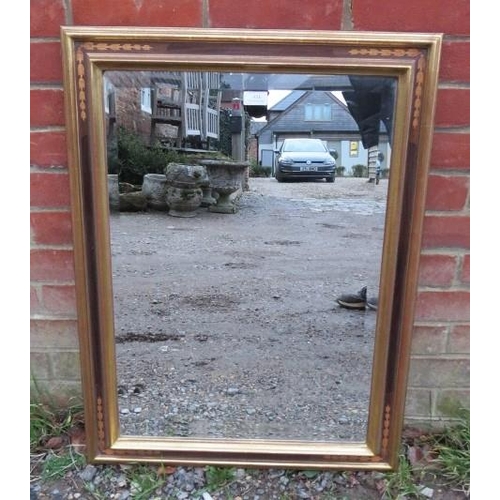 851 - A rectangular bevelled wall mirror within a parcel gilt and inlaid surround. 
H82cm W62cm (approx).
... 