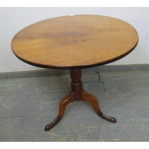 874 - An early 19th century mahogany tilt-top supper table of good colour, on a tapered turned pedestal wi... 