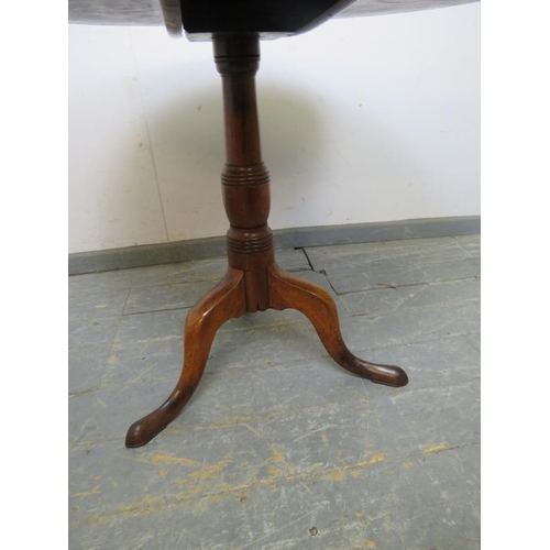 874 - An early 19th century mahogany tilt-top supper table of good colour, on a tapered turned pedestal wi... 