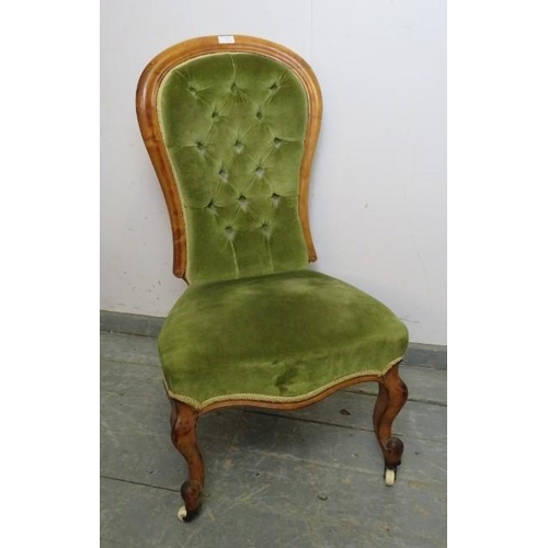 875 - A Victorian walnut show-wood bedroom chair, upholstered in buttoned green velvet material, on ogee s... 