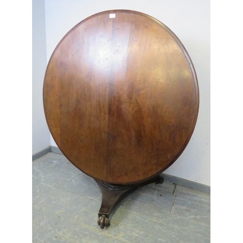 877 - An early 19th Century mahogany breakfast table, on a tapered octagonal column, the triform base havi... 