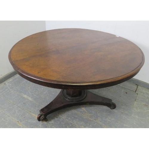 877 - An early 19th Century mahogany breakfast table, on a tapered octagonal column, the triform base havi... 