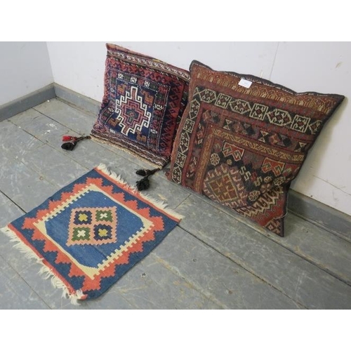 888 - Two scatter cushions, recovered with antique Persian carpets, together with a small hand-woven rug. ... 