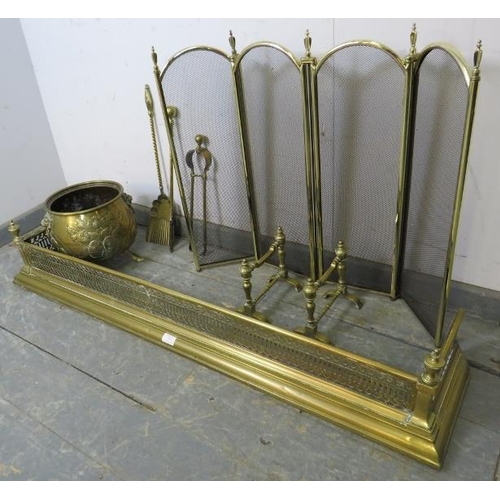 893 - An Edwardian Regency Revival pierced brass fire fender and a 19th century coal bucket, having emboss... 