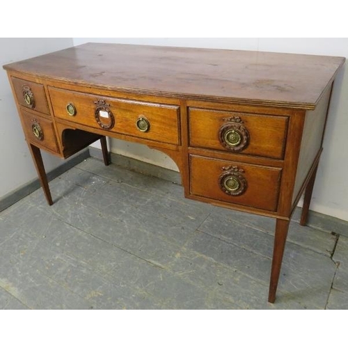 894 - An antique mahogany bow-fronted kneehole writing desk, having a configuration of five drawers with b... 