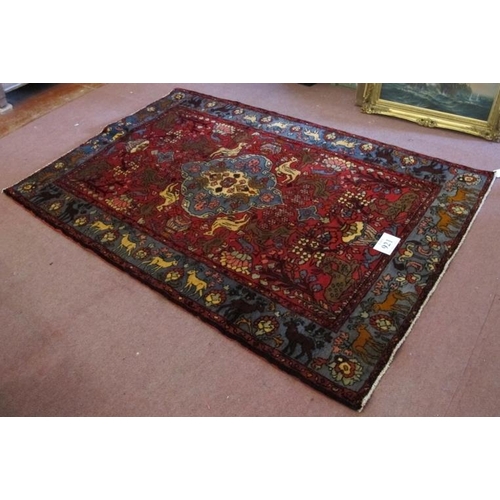 921 - A North West Persian Nahawand rug, blue on red ground with styalised animals. 195cm x 132cm (approx)... 