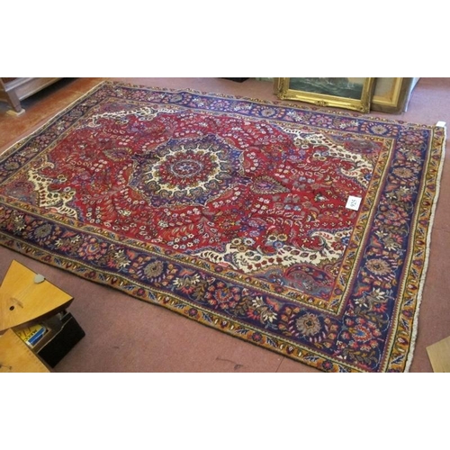 925 - North west Tabriz carpet, central motif on a deep red ground and wide blue border. 305cm x 200cm (ap... 