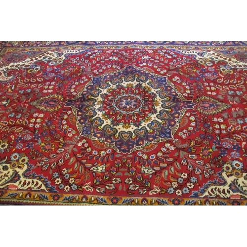 925 - North west Tabriz carpet, central motif on a deep red ground and wide blue border. 305cm x 200cm (ap... 