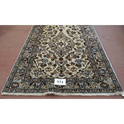 934 - A central Persian Kashan rug. Central motif and floral design on cream ground. 180cm x 105cm (approx... 