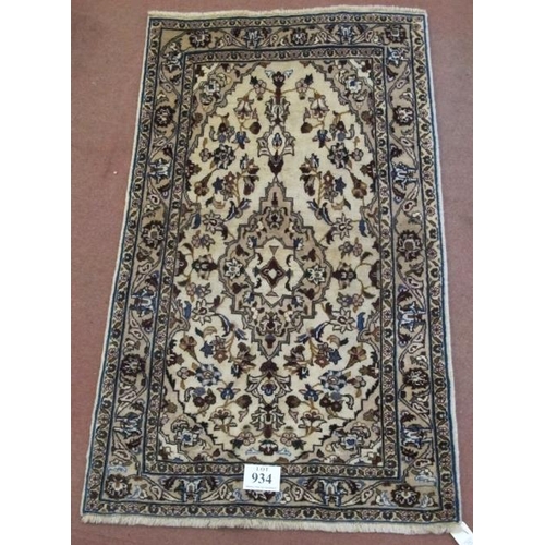 934 - A central Persian Kashan rug. Central motif and floral design on cream ground. 180cm x 105cm (approx... 