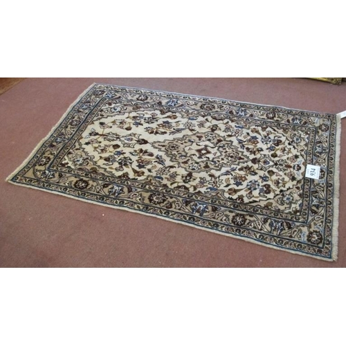 934 - A central Persian Kashan rug. Central motif and floral design on cream ground. 180cm x 105cm (approx... 