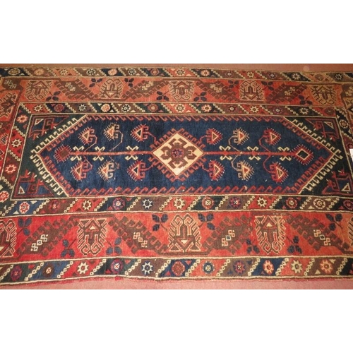 944 - A 20th Century Turkish Dosemalti rug, central motif on blue ground and wide pale red borders, 213cm ... 