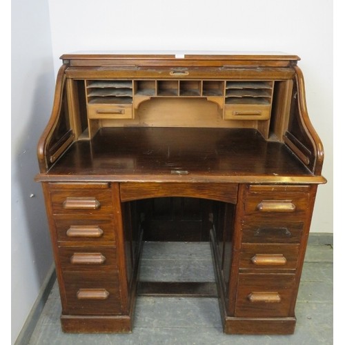 720A - An Art Deco walnut 'S-type' roll-top desk, of usable proportions, the tambour door opening onto a fi... 