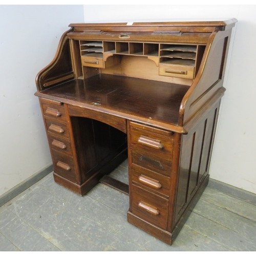 720A - An Art Deco walnut 'S-type' roll-top desk, of usable proportions, the tambour door opening onto a fi... 