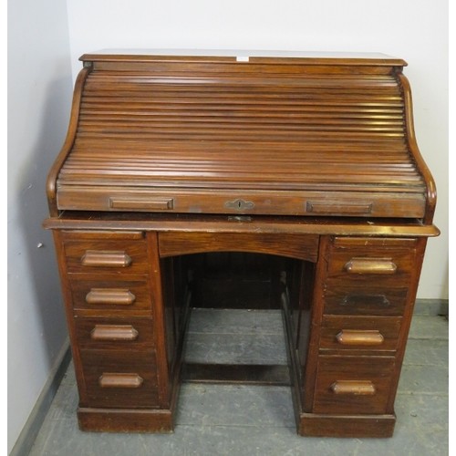 720A - An Art Deco walnut 'S-type' roll-top desk, of usable proportions, the tambour door opening onto a fi... 